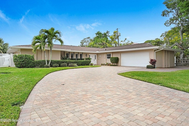 single story home with a garage and a front lawn