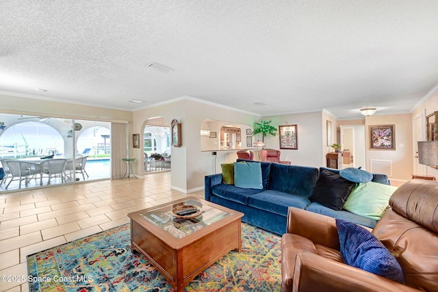 living room featuring ornamental molding, light tile patterned floors, and a textured ceiling