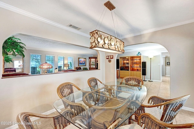 dining space featuring light tile patterned floors and crown molding