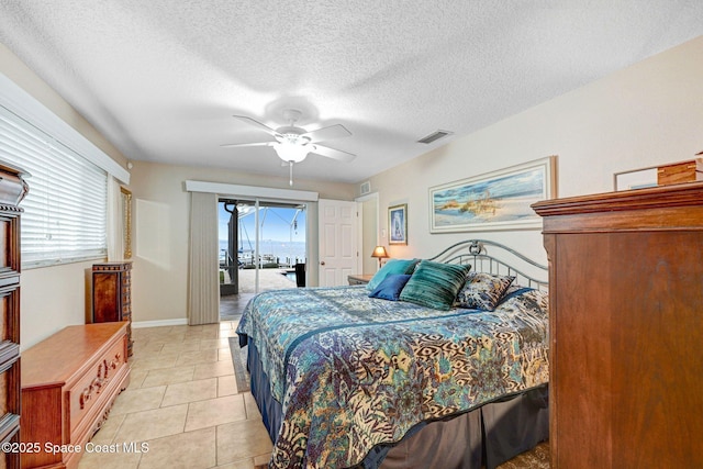 tiled bedroom featuring ceiling fan, a textured ceiling, and access to outside