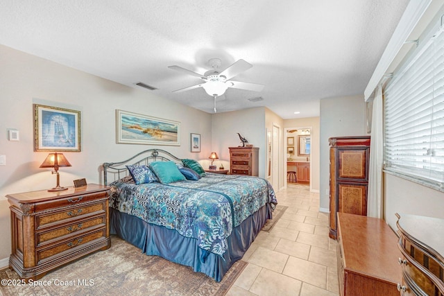 tiled bedroom with ceiling fan, a textured ceiling, and ensuite bathroom