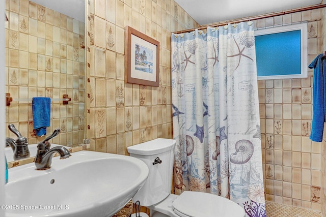 bathroom with tile walls, sink, a shower with curtain, and toilet