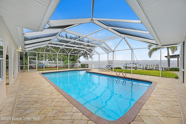 view of pool featuring a water view, a patio, and glass enclosure