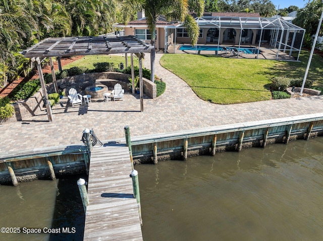 dock area with a patio area, a water view, a lawn, a lanai, and a fire pit