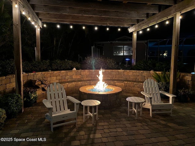 patio at twilight featuring a pergola and a fire pit