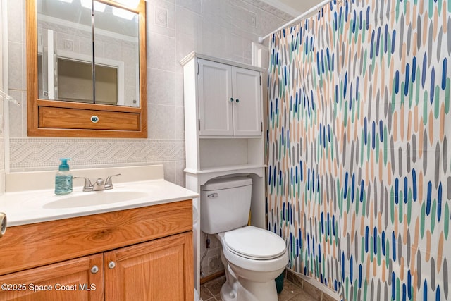 bathroom with tile walls, toilet, vanity, and a shower with curtain