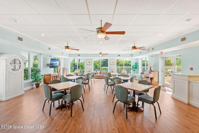 dining room featuring a paneled ceiling and light hardwood / wood-style flooring