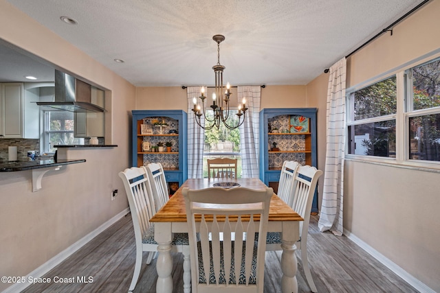 dining area featuring a textured ceiling, baseboards, and dark wood-style flooring