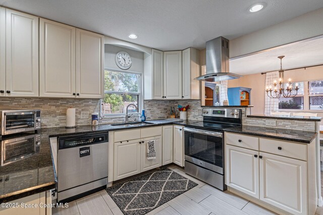 kitchen with a toaster, island range hood, dark countertops, stainless steel appliances, and a sink