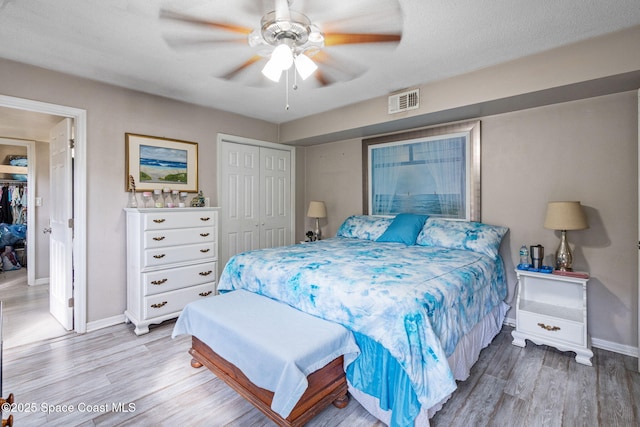 bedroom featuring light wood-type flooring, a closet, visible vents, and baseboards