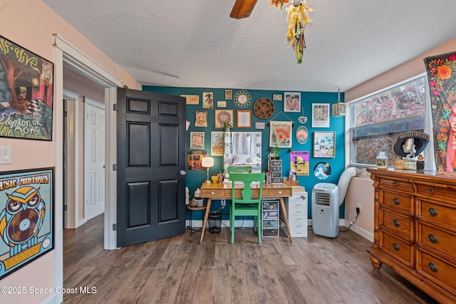 office space featuring a textured ceiling, baseboards, and wood finished floors