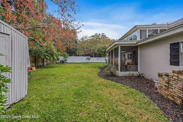 view of yard featuring a sunroom and a fenced backyard