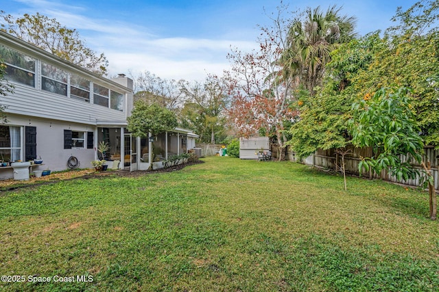 view of yard with a fenced backyard and a sunroom