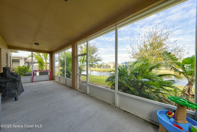 unfurnished sunroom featuring a water view