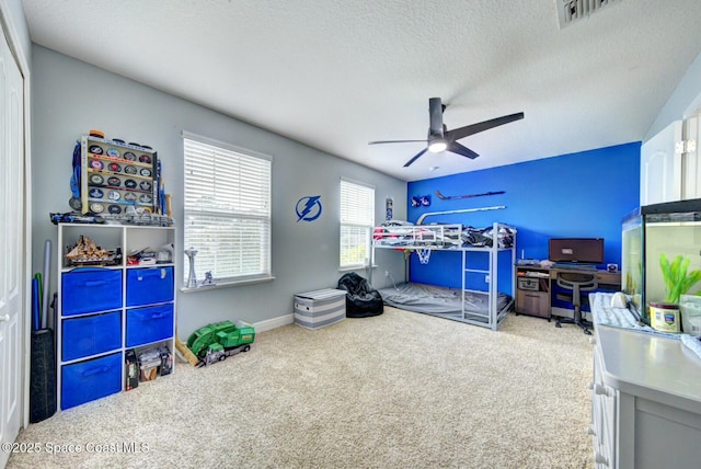 carpeted bedroom featuring a textured ceiling and ceiling fan