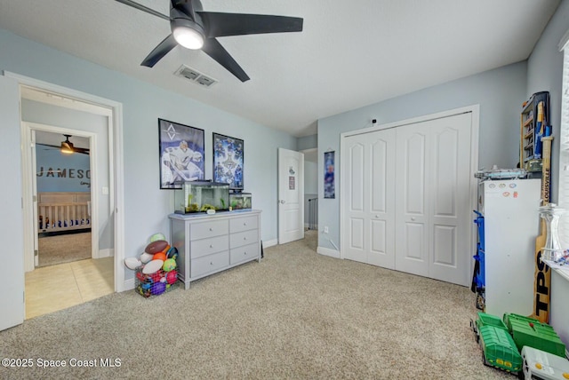 interior space featuring a closet, visible vents, a ceiling fan, light carpet, and baseboards