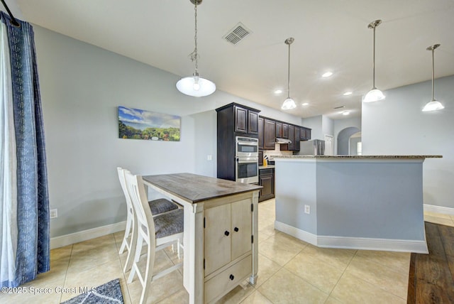 kitchen with visible vents, dark brown cabinets, appliances with stainless steel finishes, and decorative light fixtures