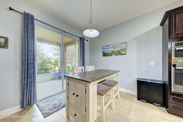 kitchen featuring decorative light fixtures, dark brown cabinets, and light tile patterned floors