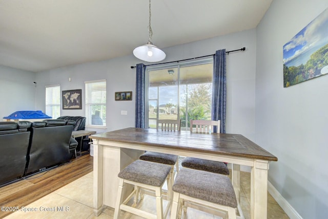 dining area featuring light wood-style floors and baseboards