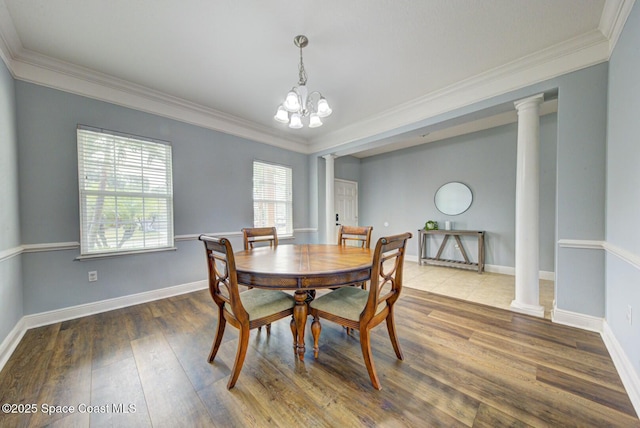 dining area featuring baseboards, wood finished floors, decorative columns, and crown molding