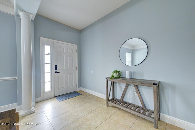 foyer featuring light tile patterned floors, crown molding, and decorative columns