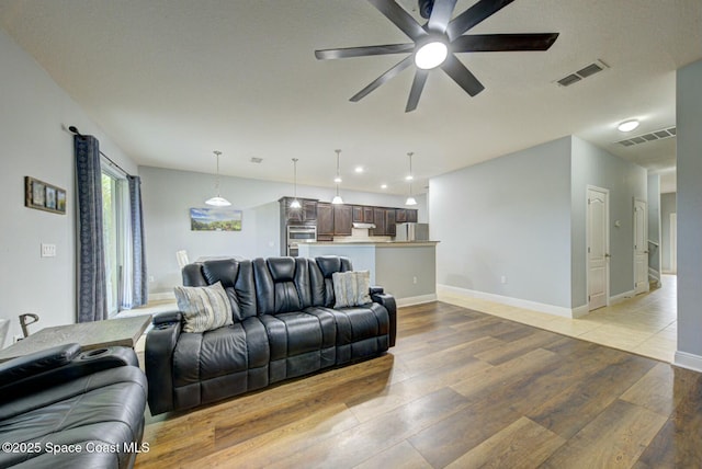 living room featuring ceiling fan and light hardwood / wood-style flooring