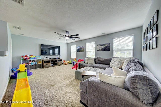 carpeted living room with ceiling fan and a textured ceiling