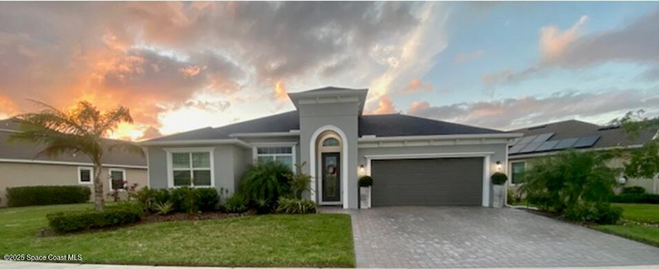 view of front of house with a garage and a yard