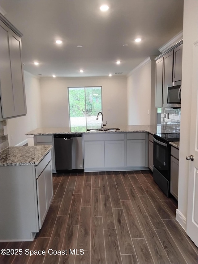 kitchen featuring sink, appliances with stainless steel finishes, gray cabinetry, light stone counters, and kitchen peninsula