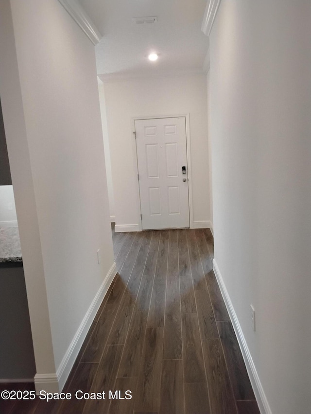 corridor with ornamental molding and dark hardwood / wood-style flooring