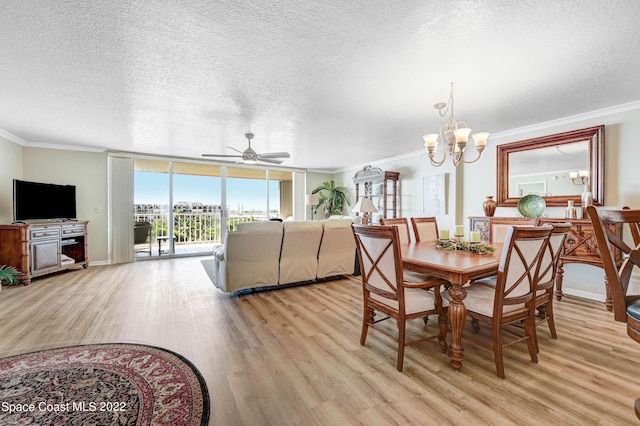 dining space featuring ornamental molding, ceiling fan with notable chandelier, a wall of windows, and light hardwood / wood-style floors