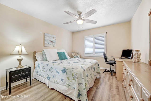 bedroom with ceiling fan, a textured ceiling, and light wood-type flooring