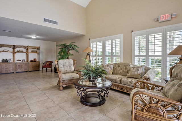 living room with plenty of natural light, a high ceiling, and light tile patterned floors