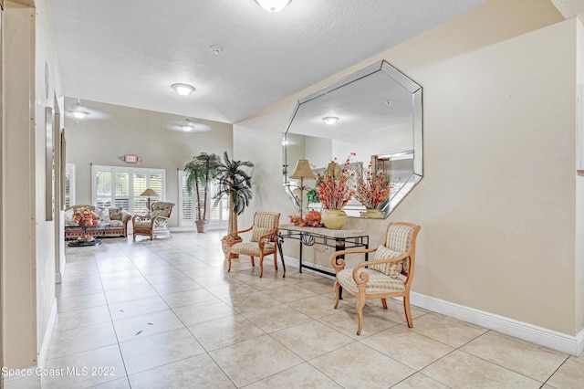 hall featuring light tile patterned floors and a textured ceiling