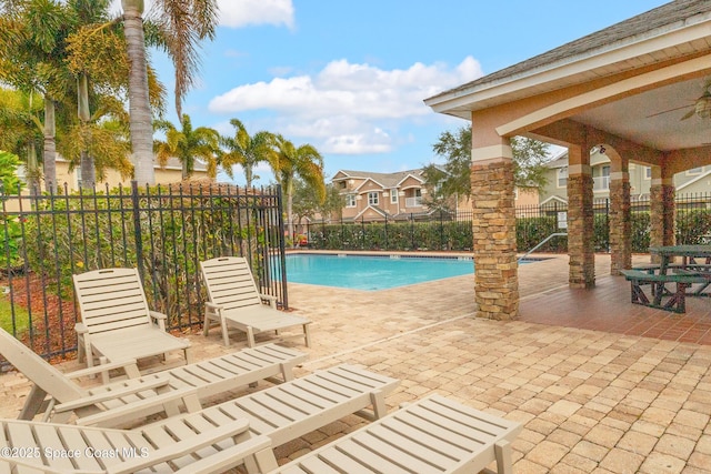 view of swimming pool featuring ceiling fan and a patio area