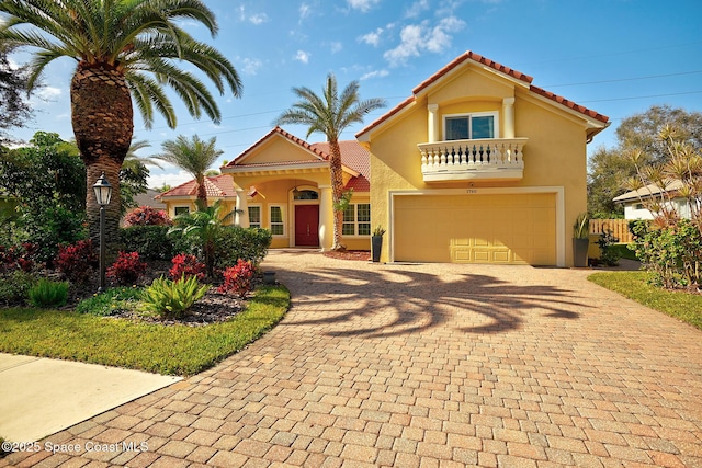 mediterranean / spanish-style home featuring a garage and a balcony