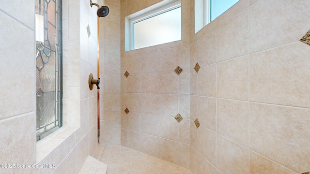 bathroom with tiled shower and a wealth of natural light