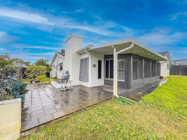 rear view of house featuring a yard and a patio area