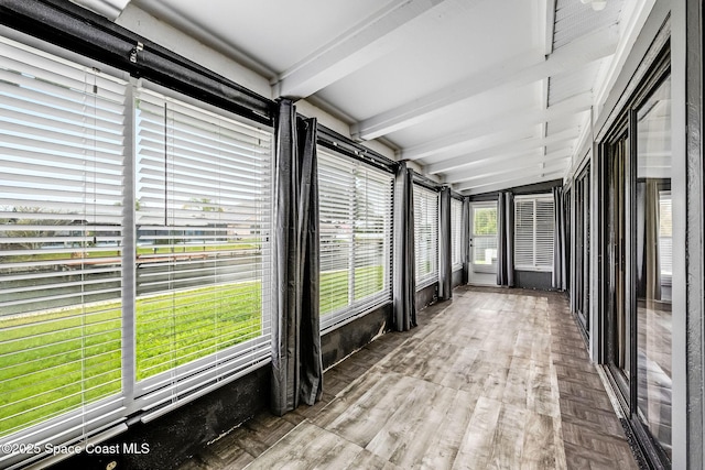 unfurnished sunroom with vaulted ceiling with beams