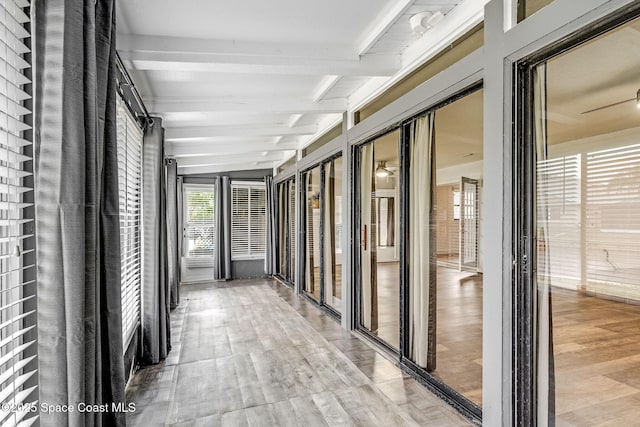 corridor featuring beamed ceiling and light hardwood / wood-style flooring