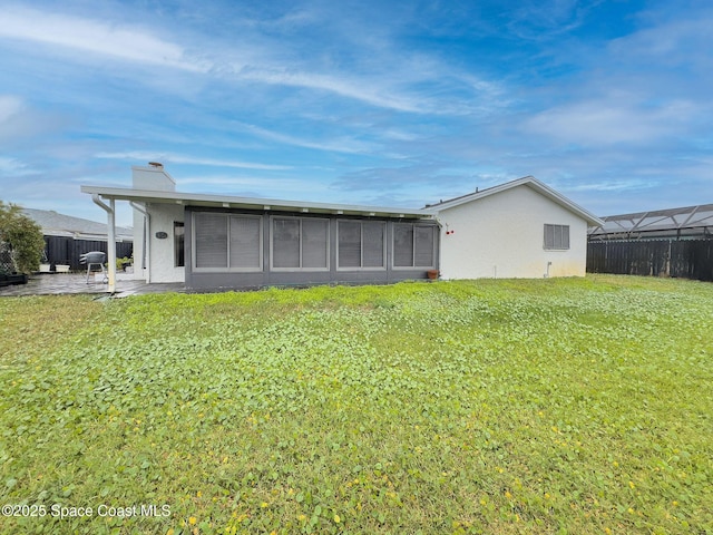 rear view of house featuring a patio area and a lawn