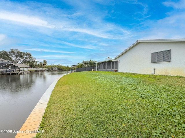 view of yard featuring a water view and a sunroom