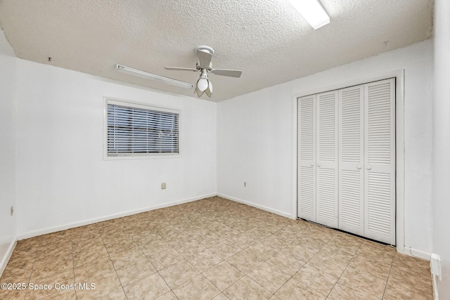 unfurnished bedroom with a textured ceiling, a closet, and ceiling fan