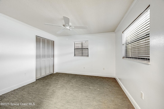 unfurnished bedroom featuring crown molding, ceiling fan, a closet, and carpet