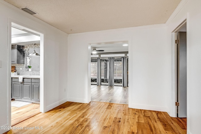 hall with crown molding and light wood-type flooring