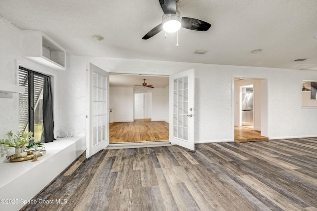 unfurnished living room featuring french doors, ceiling fan, hardwood / wood-style floors, and a textured ceiling