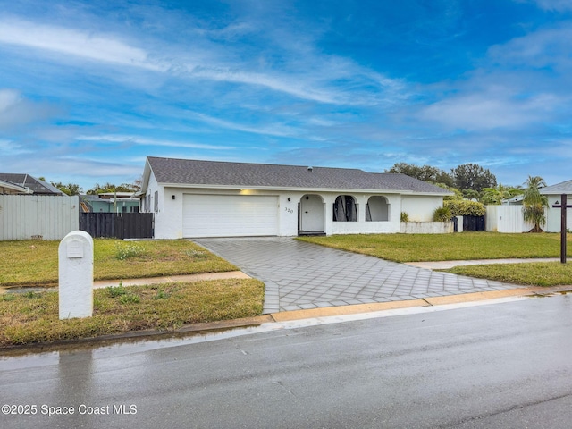 ranch-style house featuring a garage and a front lawn