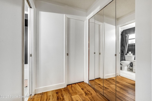 unfurnished bedroom with hardwood / wood-style flooring, ensuite bath, and a closet