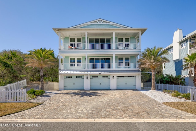 raised beach house featuring a balcony and a garage