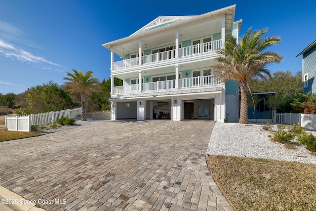 coastal inspired home featuring a carport, a balcony, and a garage